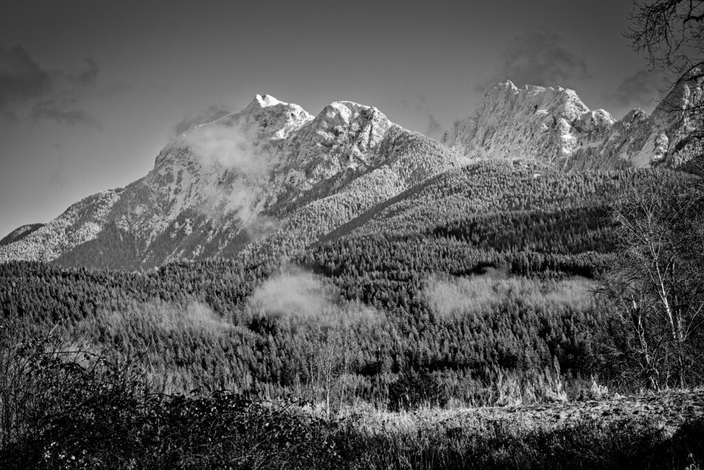 Black and white image of Golden Ears on Mount Blanshard with the peaks illuminated in early morning light.